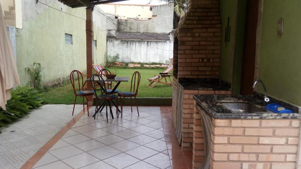 d'une terrasse avec une table, des chaises et un évier. dans l'établissement Casa de Praia em São Pedro da Aldeia, à São Pedro da Aldeia