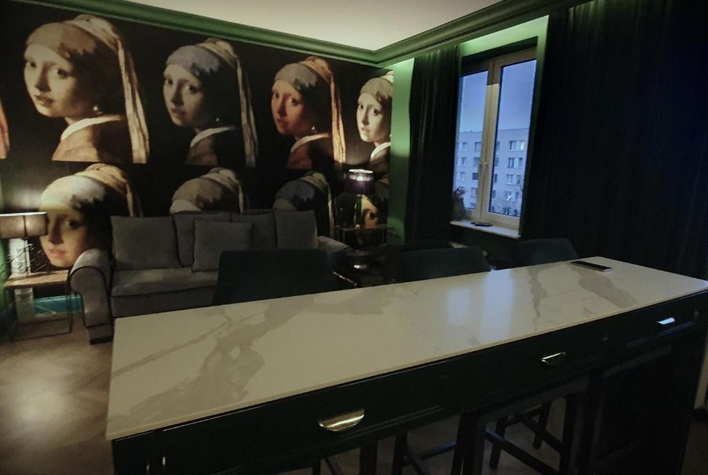 una habitación con una mesa y una pintura de mujeres en City Center by Better Place, en Varsovia