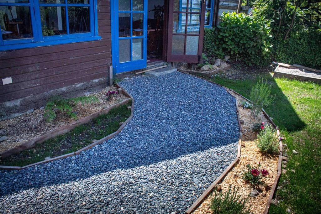 a yard with a house and a gravel driveway at Cabaña con vista al Lago in Ranco