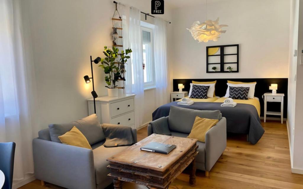 a bedroom with a bed and two chairs and a table at Boennium Apartments in Ljubljana