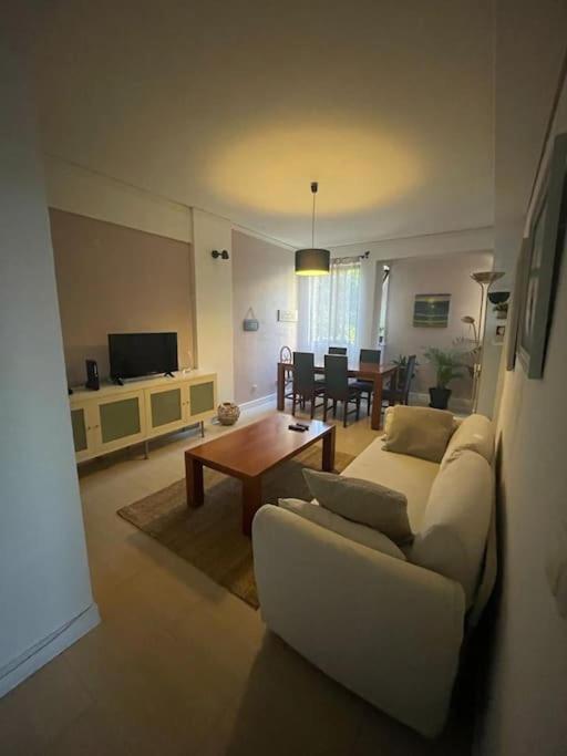 a living room with a white couch and a table at Daloba House in Costa da Caparica