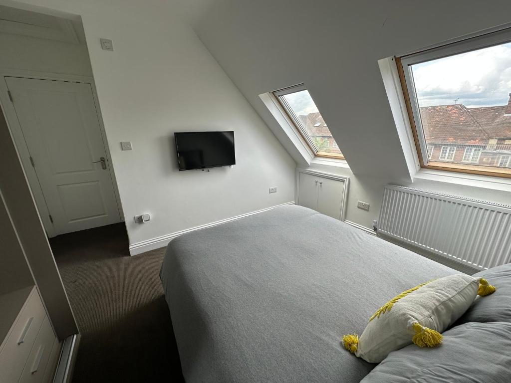 una camera con letto e TV a parete di Stunning Modern, Brand-New 1 Bed Flat Only 15 Mins To Central London a The Hyde