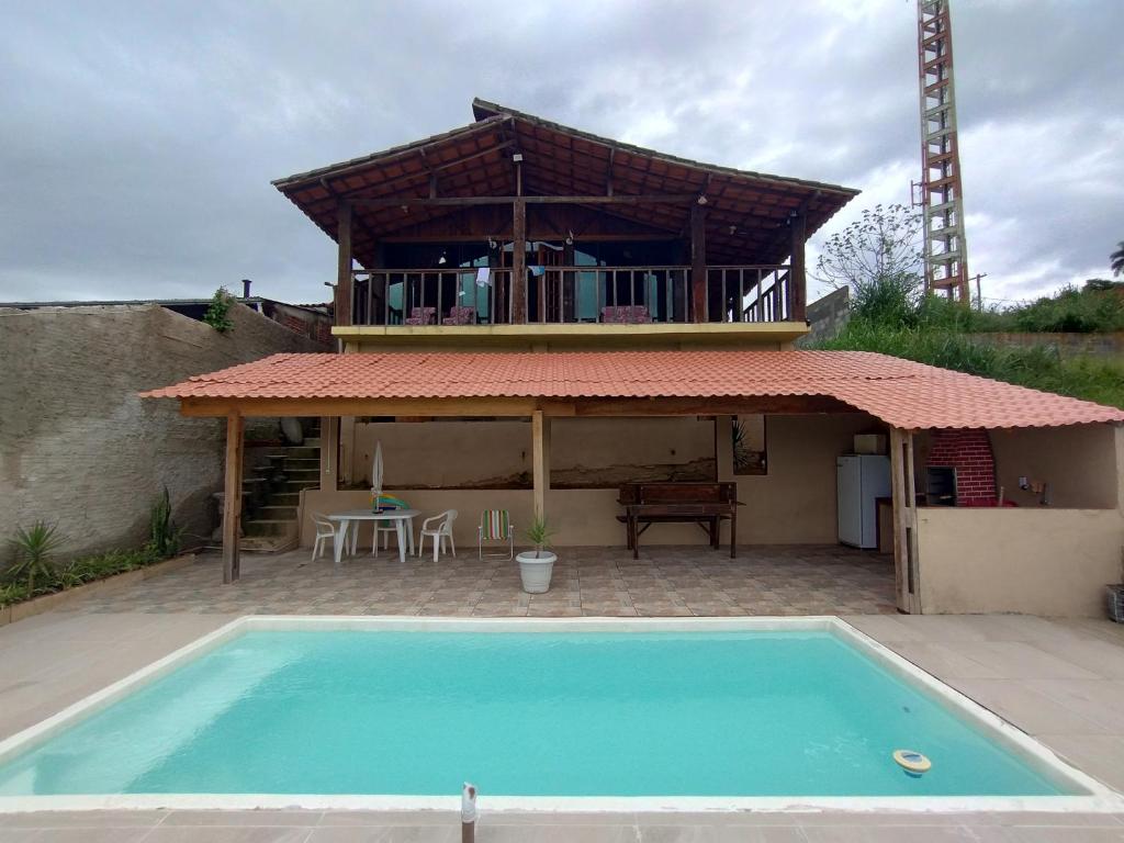 uma casa com piscina em frente a uma casa em Casa de Tijolinho Penedo-RJ em Penedo