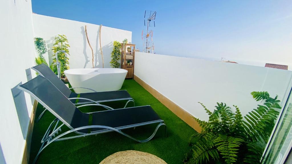 - Balcón con 2 sillas y bañera en un edificio en Big House Adeje Deluxe By Deihu Experiences, en Adeje