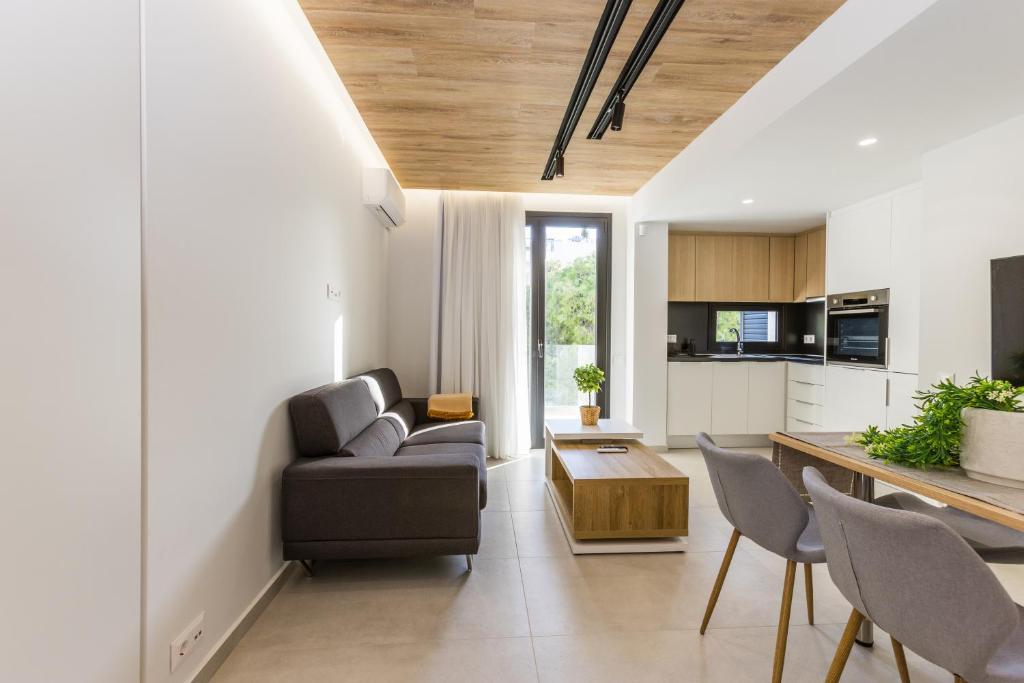 a living room with a couch and a table at Varkiza Luxury Suites by Raise in Vari