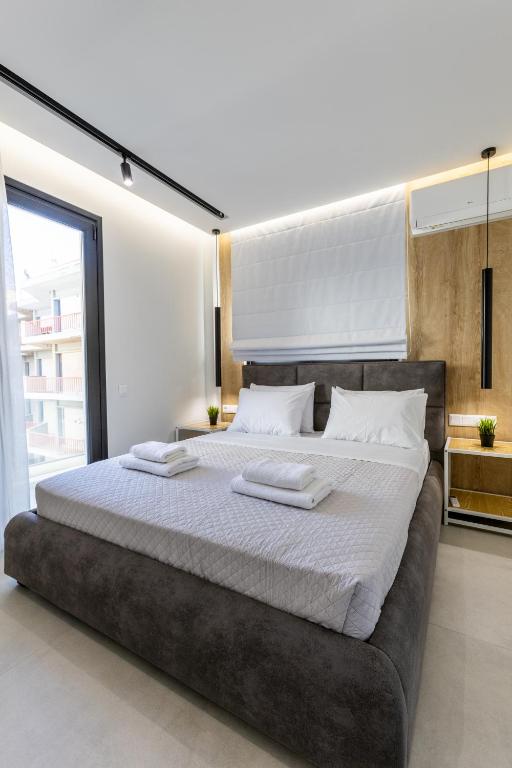 a bedroom with a large bed with two towels on it at Varkiza Luxury Suites by Raise in Vari