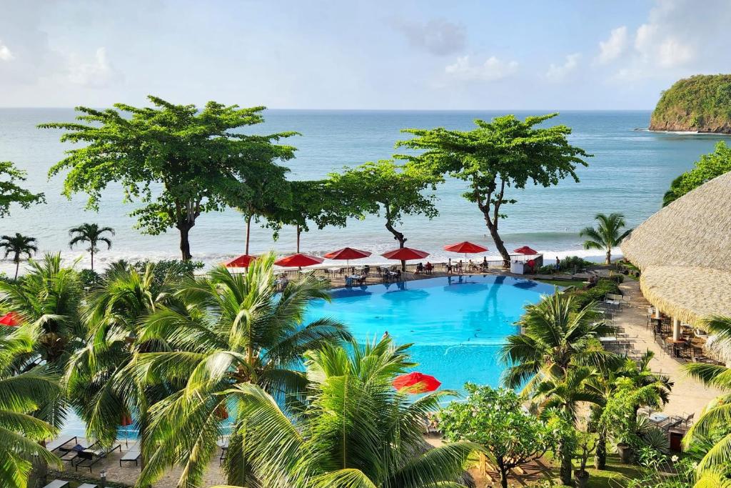 een uitzicht op een resort met een zwembad en de oceaan bij Poema's Beach Duplex in Arue