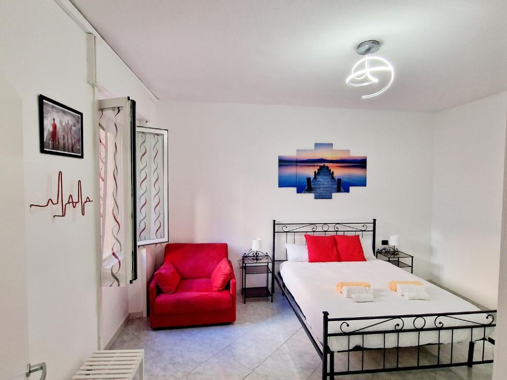 a bedroom with a bed and a red chair at FUORI dal COMUNE in Corsico