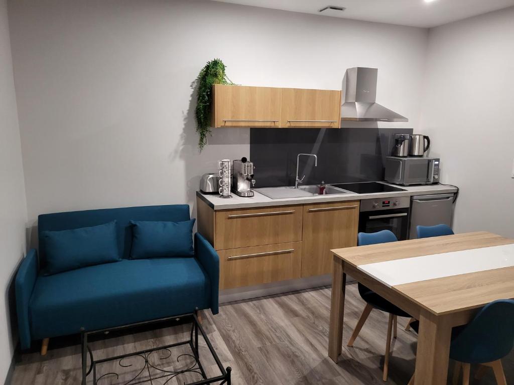 a kitchen with two blue chairs and a table at BONHEUR in La Souterraine