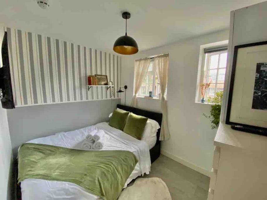 een kleine slaapkamer met een bed en een televisie bij One bedroom Putney Village flat in Londen