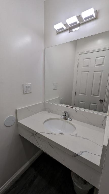 a white bathroom with a sink and a mirror at Airport Motel - Inglewood in Inglewood