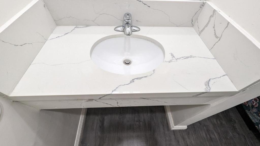 a bathroom sink with a white marble counter top at Airport Motel - Inglewood in Inglewood