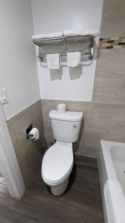 a bathroom with a toilet and a sink and a tub at Airport Motel - Inglewood in Inglewood