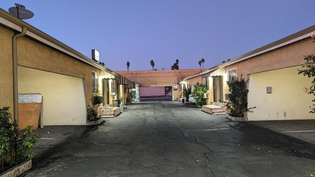 an empty alley between two buildings with trees in the background at Airport Motel - Inglewood in Inglewood