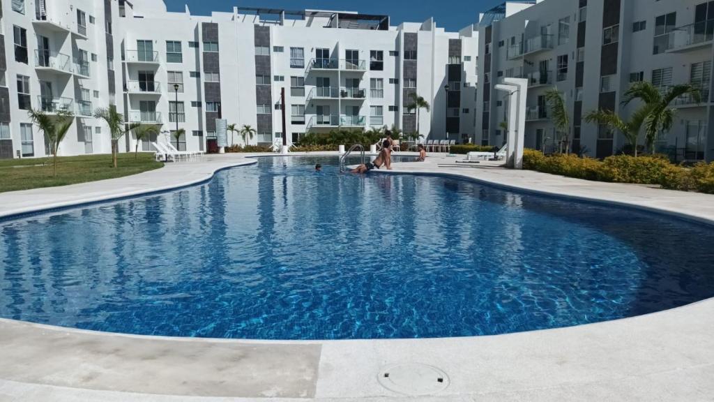 ein Pool vor einigen Apartmentgebäuden in der Unterkunft Departamento en Acapulco Diamante in Acapulco