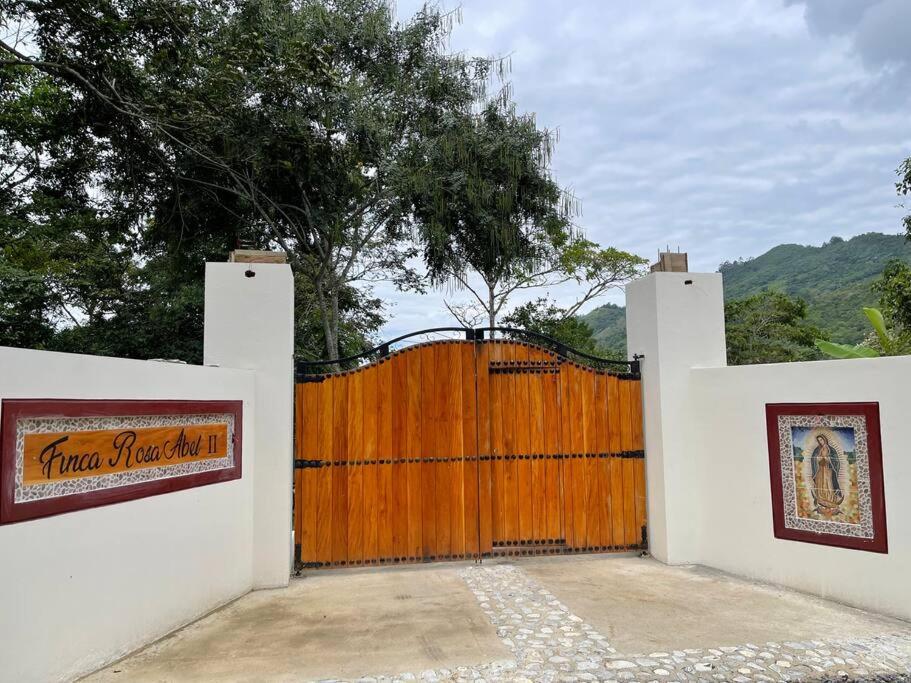 a wooden fence with a gate with a wooden at Hermosa Cabaña cerca a Villeta in Quebradanegra