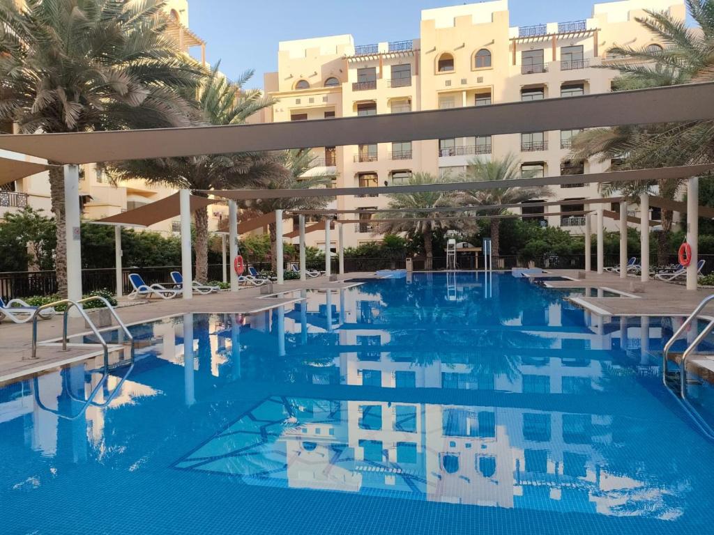 a swimming pool in front of a large building at 1Bedroom Luxury Apartment By Mamzar Beach in Dubai