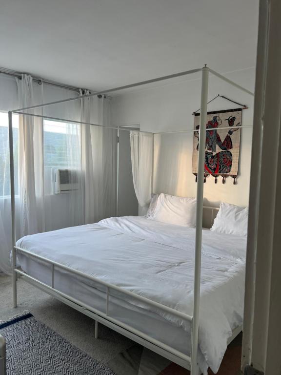 a white bed with a canopy in a bedroom at Laurel house weho historic district in Los Angeles