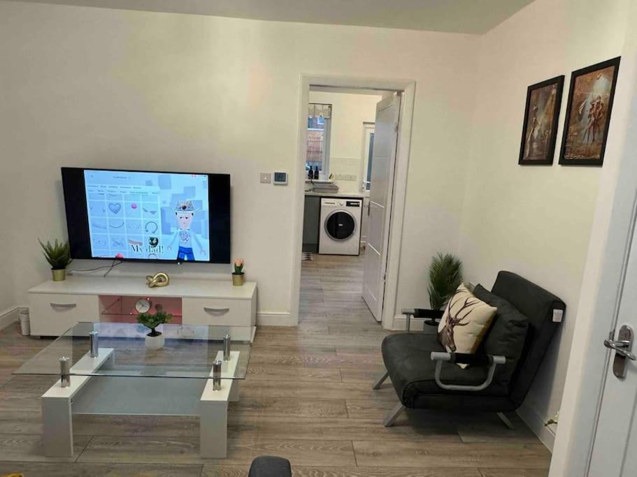 - un salon avec une télévision, un canapé et une table dans l'établissement The Ideal Spacious Home, à Birmingham