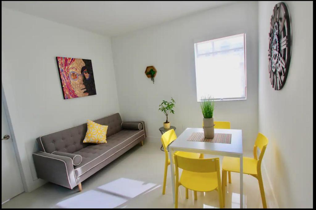 uma sala de estar com um sofá e uma mesa em 1 Stylish SoBe Condo 1/2 Block From The Beach!!! em Miami Beach