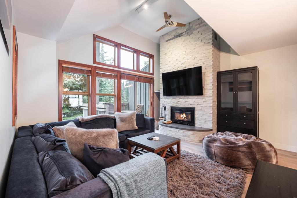 a living room with a couch and a fireplace at Treeline by Outpost Whistler in Whistler