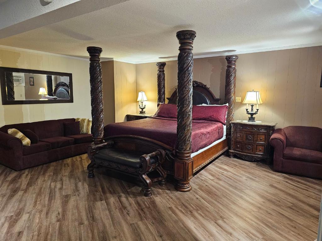 a bedroom with a large bed and a couch at Parkway Motel & European Lodges in Pincher Creek