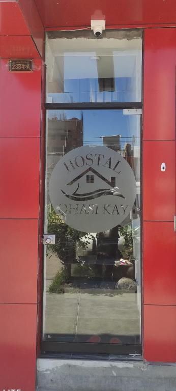 a reflection of a sign in the window of a building at Hostal Qhasi Kay in Huancayo