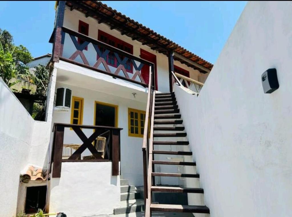 a stairway leading up to a white house at Apartamentos Charmosos na Avenida Principal de Buzios in Búzios