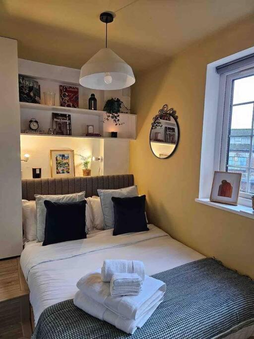 een slaapkamer met 2 bedden en handdoeken bij West Kensington flat, balcony in Londen