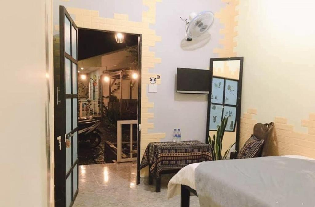 a bedroom with a bed and a mirror and a doorway at Homestay Vườn nhãn in Pleiku