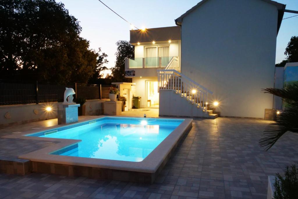 a swimming pool in front of a house at night at Family friendly house with a swimming pool Vinovac, Zagora - 22041 in Blizna Donja