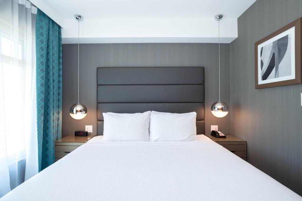 Postel nebo postele na pokoji v ubytování Sandman Signature Calgary Airport Hotel
