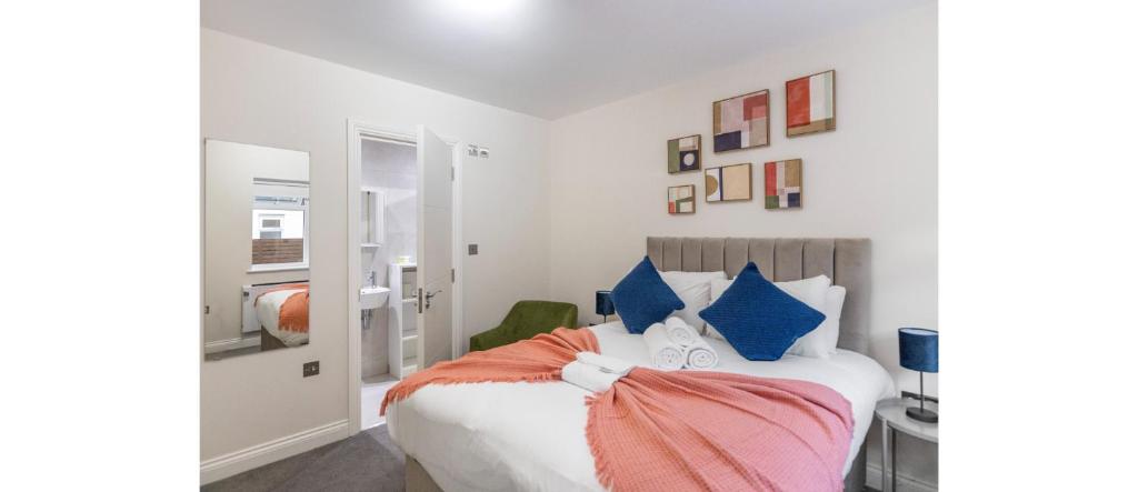 a bedroom with a bed with blue and orange pillows at Tranquil Retreat in Hendon: Comfort & Style Await in The Hyde