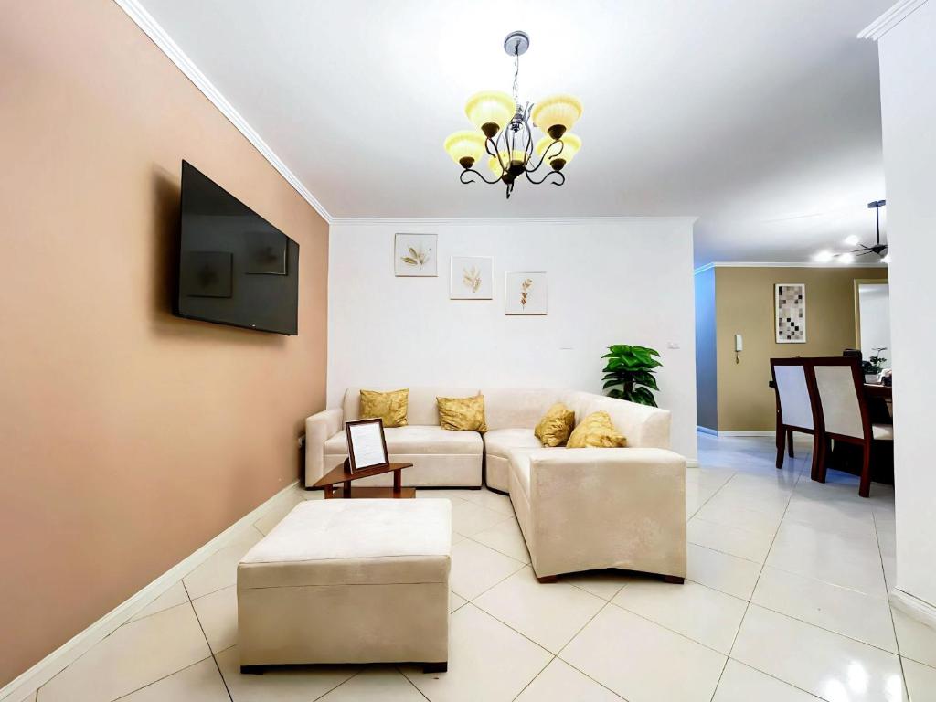 sala de estar con sofá y TV en Apartamento en la mejor ubicación, centro de Loja, en Loja