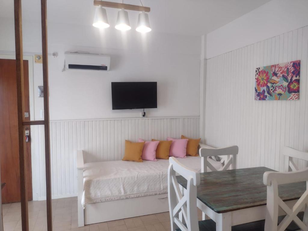 Habitación con cama con almohadas de color rosa y naranja en Departamento en Zona Unzue en Mar del Plata