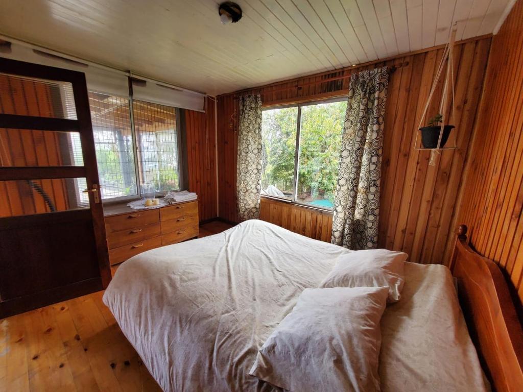 ein Schlafzimmer mit einem großen Bett und einem Fenster in der Unterkunft Acogedora Cabaña en la playa in Valdivia