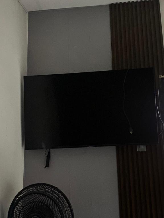 uma televisão de ecrã plano pendurada numa parede com uma ventoinha em Departamento Basico em Guayaquil