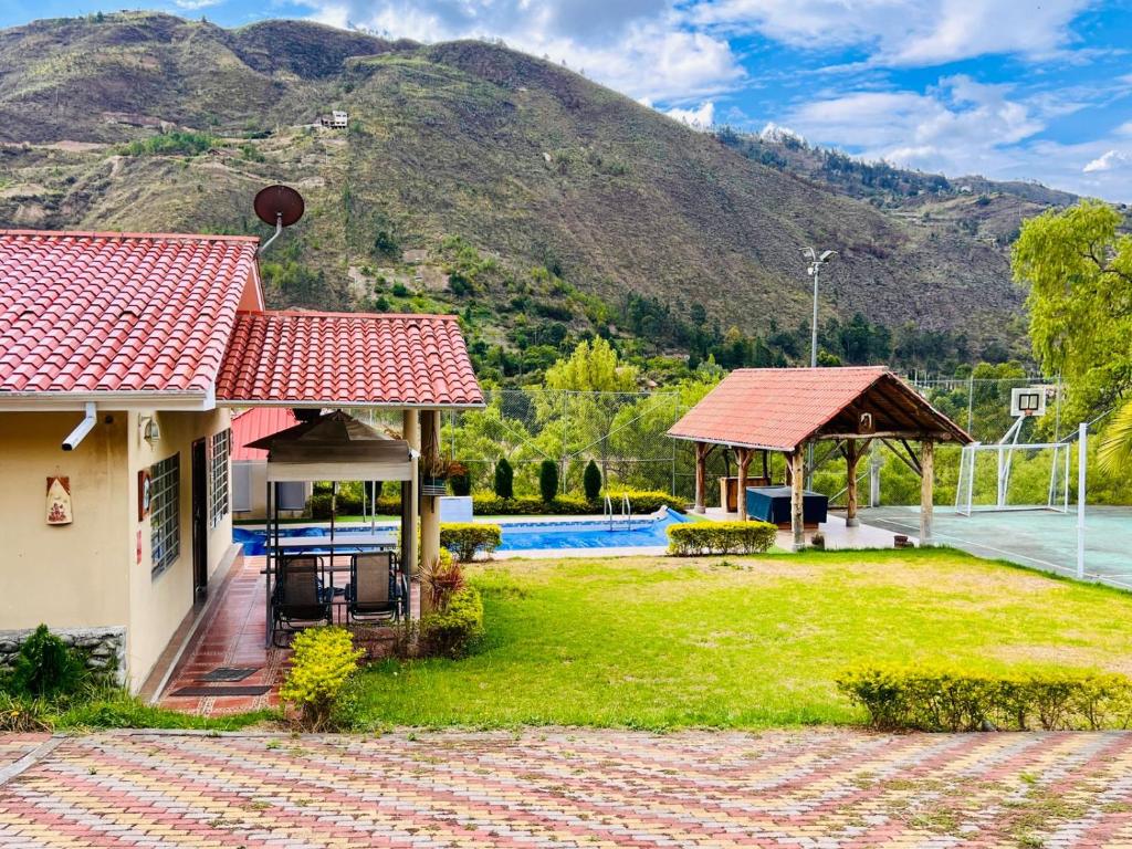 a house with a garden and a mountain in the background at Quinta Estefanía, Paute-Uzhupud in Cuenca