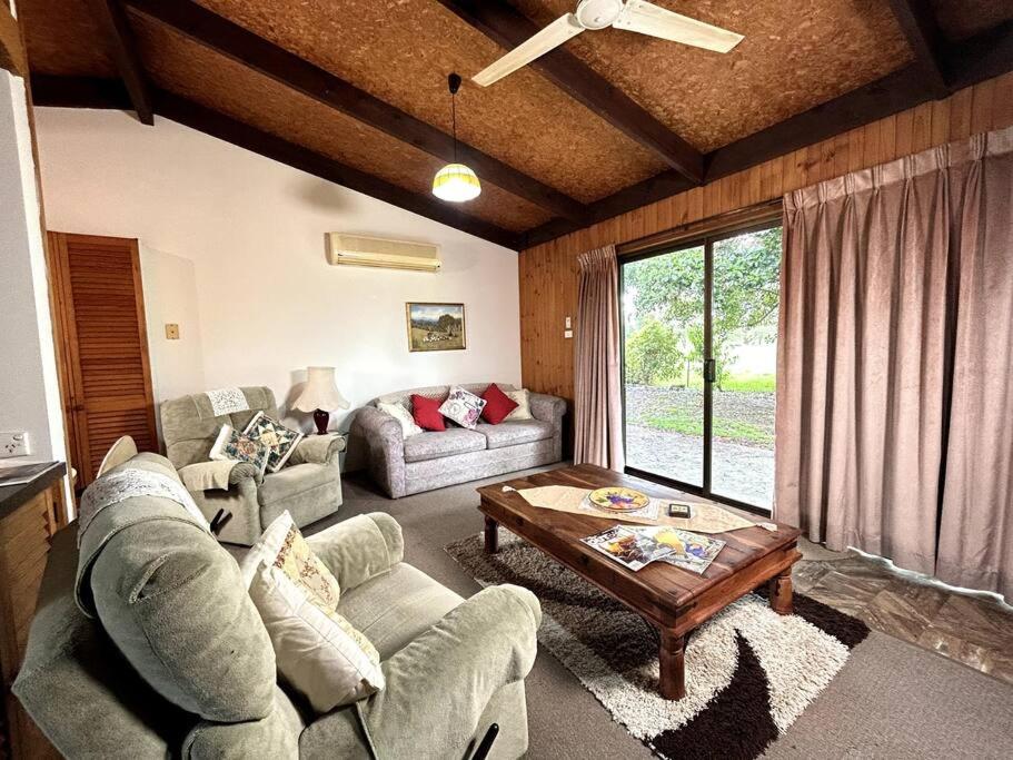 a living room with a couch and a table at Grassvale Farms Retreat - Lodge in Lindenow