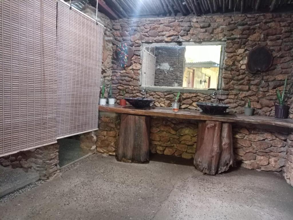 a stone bathroom with two sinks and a mirror at Villas del Mar Hostal in Cañas