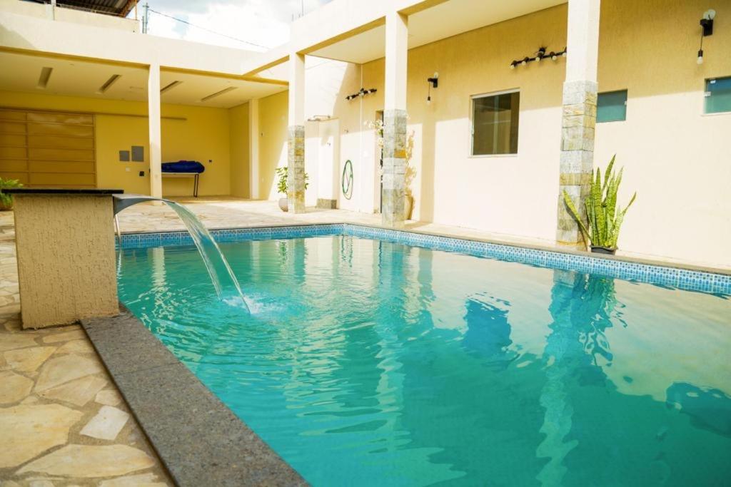 - une piscine avec une fontaine dans un bâtiment dans l'établissement Damissele, à Betim