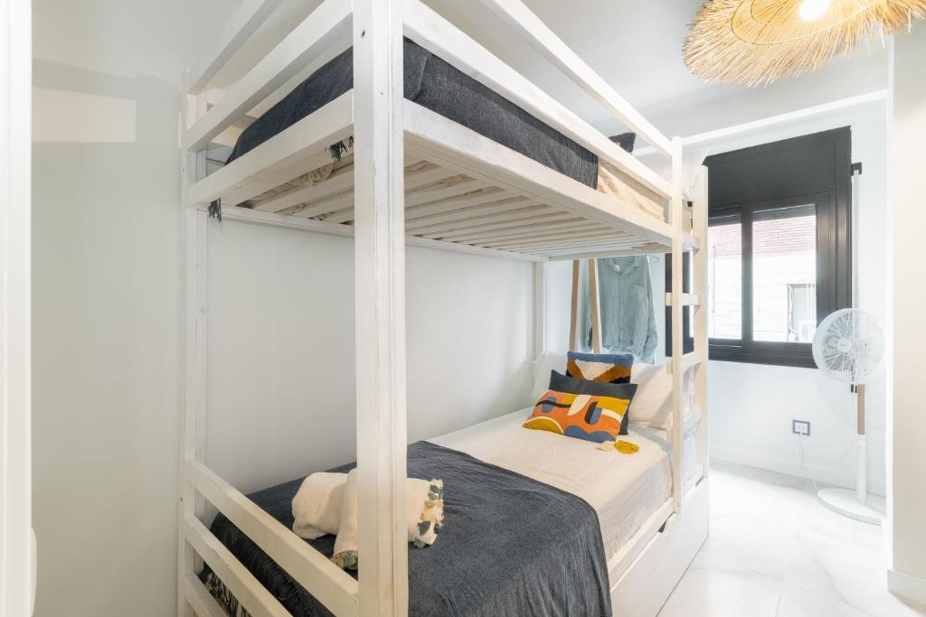 um quarto com beliches num quarto branco em En Calma por el Mediterráneo. em Sant Adria de Besos
