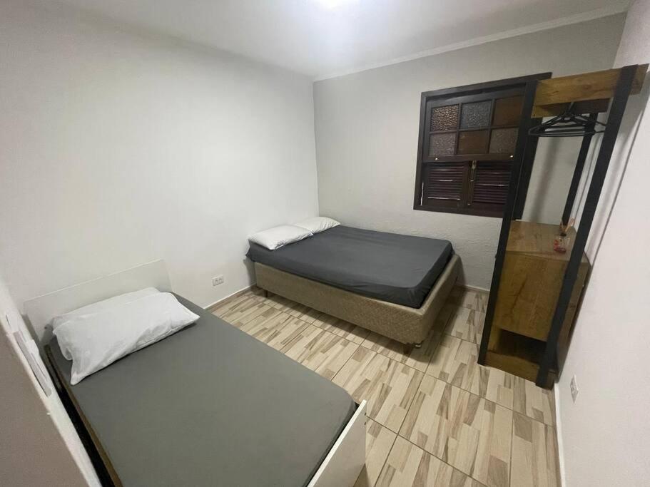 um pequeno quarto com 2 camas e uma janela em Chácara Cantinho Castanheira a 40 min de SP prox Itu e Sorocaba em Itu