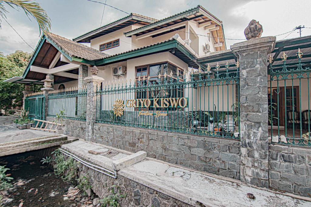 a house with a fence in front of it at Griyo Kiswo Vacation Home in Lawean