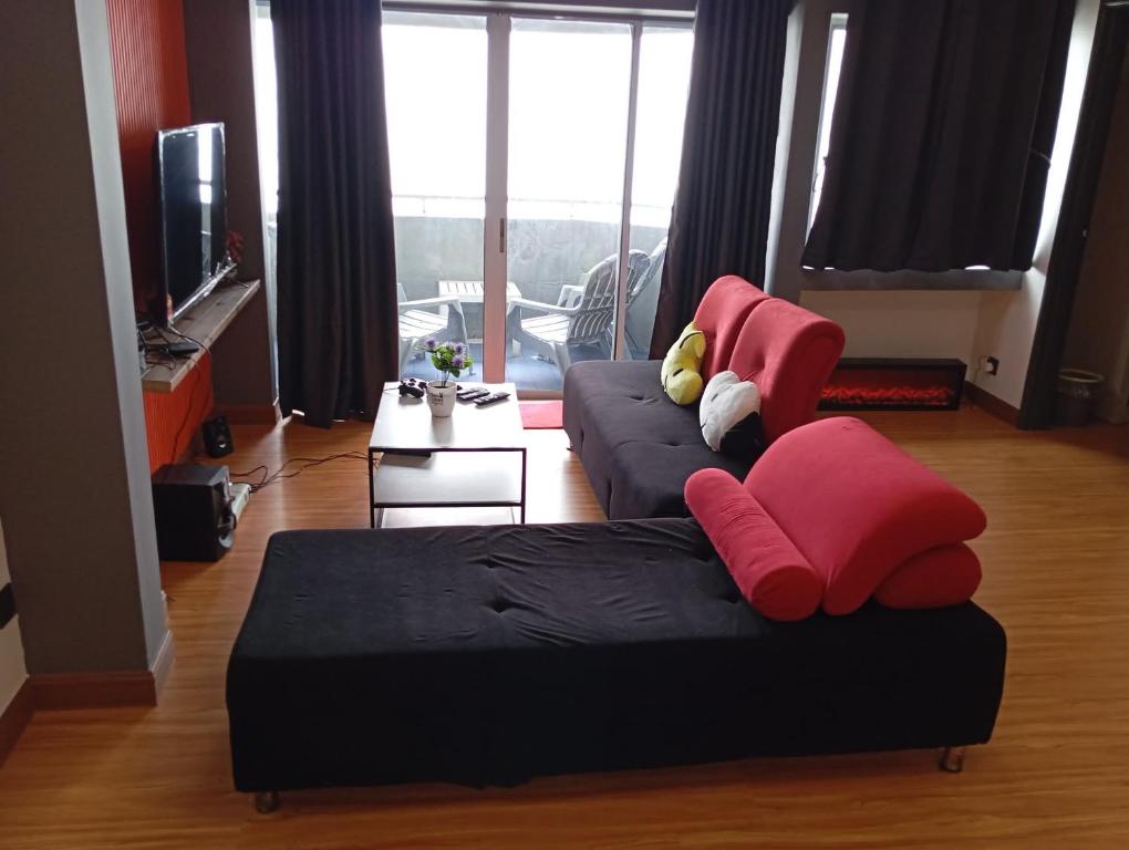 ein Wohnzimmer mit zwei Sofas und einem Fernseher in der Unterkunft 10Pax Deluxe Apartment, CloudView Snoopy Theme, Golden Hills Resort Genting, Formerly Known as Amber Court in Genting Highlands