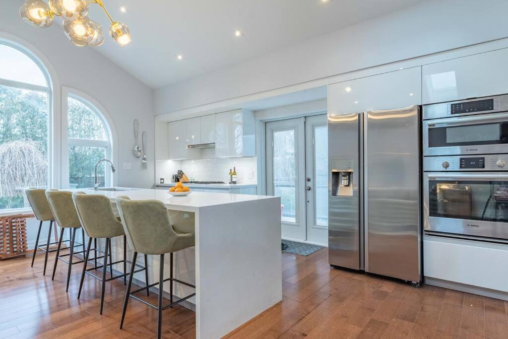 a kitchen with a white counter and a refrigerator at Luxurious & Modern 4BR House w/ 3 Car Parking in Burlington