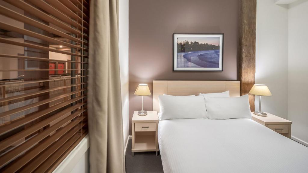 Una cama o camas en una habitación de Oaks Sydney Goldsbrough Suites
