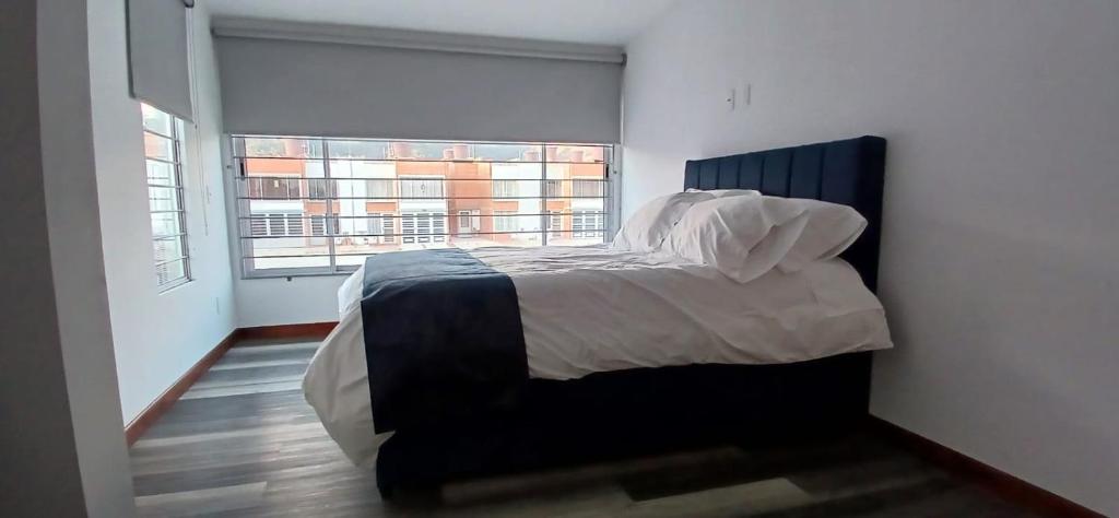 a bedroom with a bed and a large window at CasAvella Paipa in Paipa