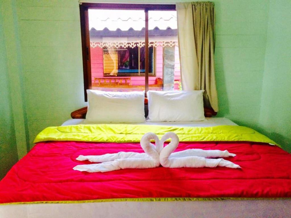 two swans laying on top of a bed at PHUPA BEACH Resort in Ban Ang