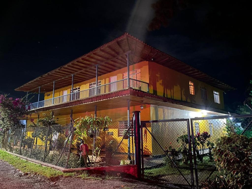 um edifício com uma vedação em frente à noite em Finca San Juan de las Araucarias Ranch em Santa Rosa de Cabal